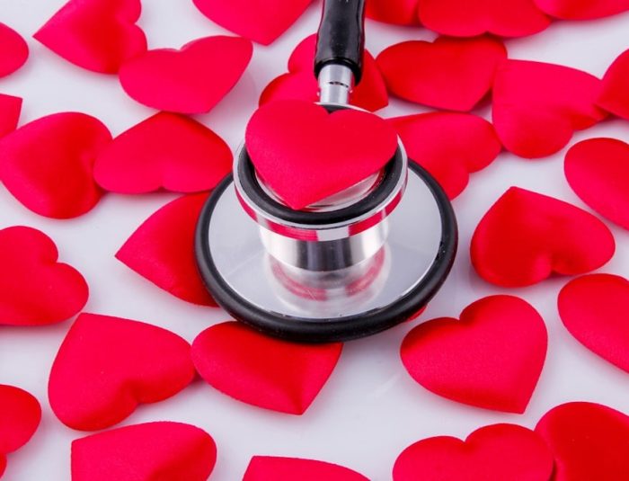 a stethoscope surrounded by hearts on a white surface